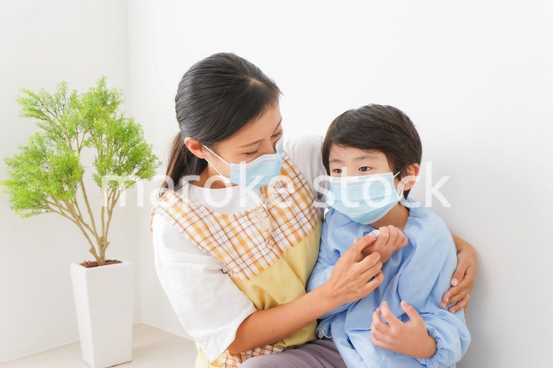 体温を測定する子供と幼稚園の先生