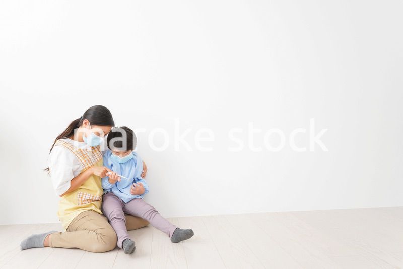 体温を測定する子供と幼稚園の先生