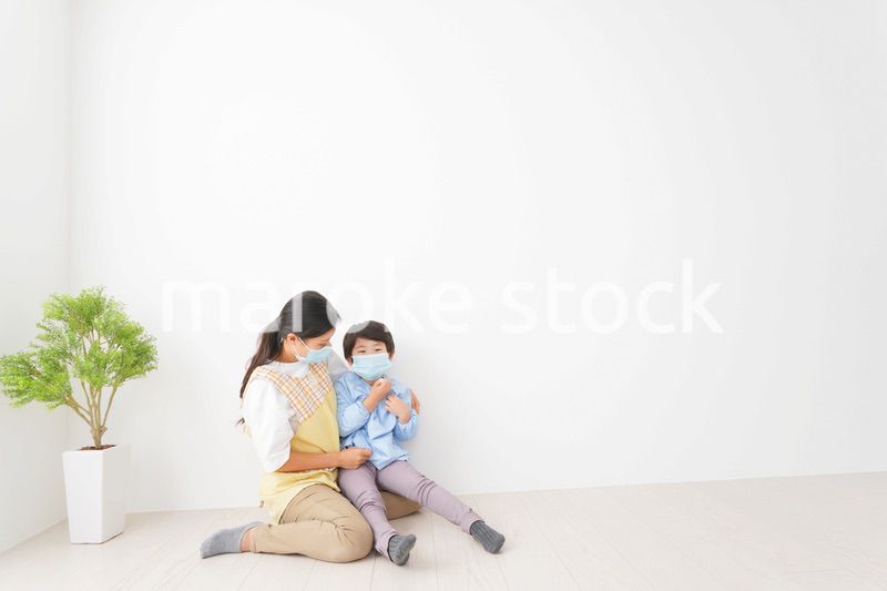 体温を測定する子供と幼稚園の先生