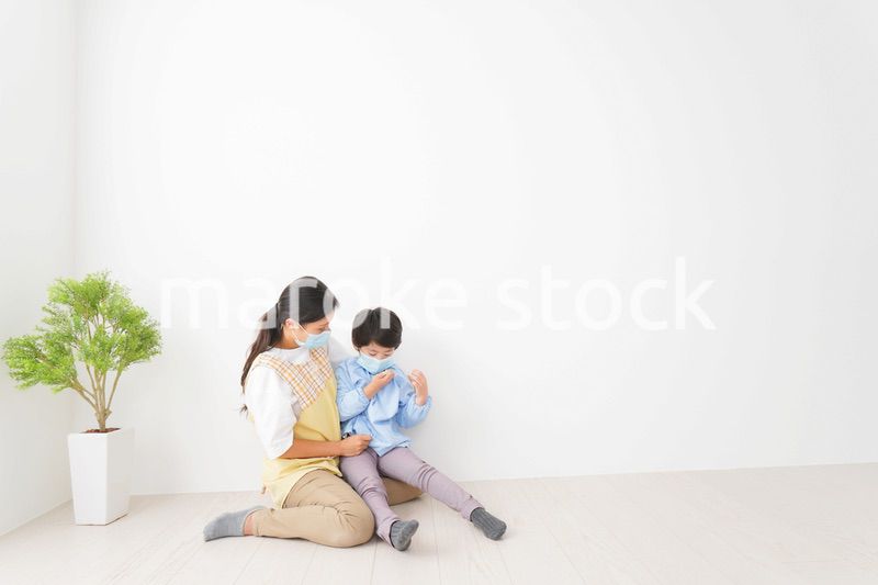 体温を測定する子供と幼稚園の先生