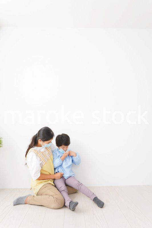 体温を測定する子供と幼稚園の先生