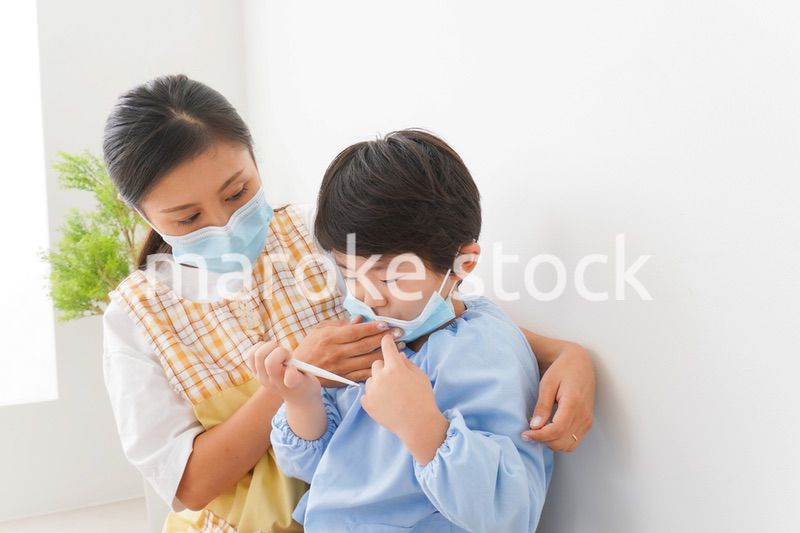 体温を測定する子供と幼稚園の先生