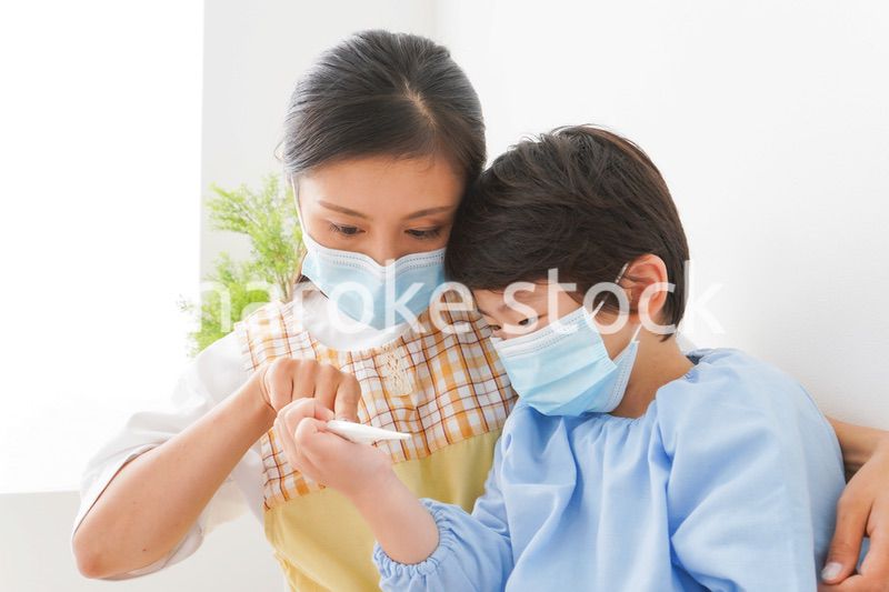 体温を測定する子供と幼稚園の先生