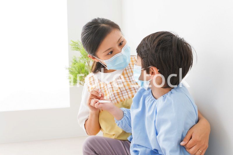体温を測定する子供と幼稚園の先生