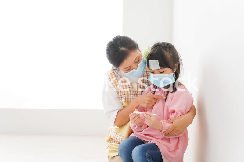 発熱した子供と幼稚園の先生