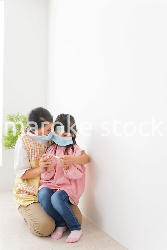 発熱した子供と幼稚園の先生