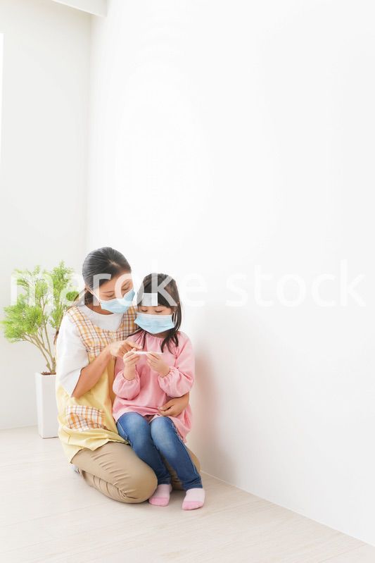 発熱した子供と幼稚園の先生