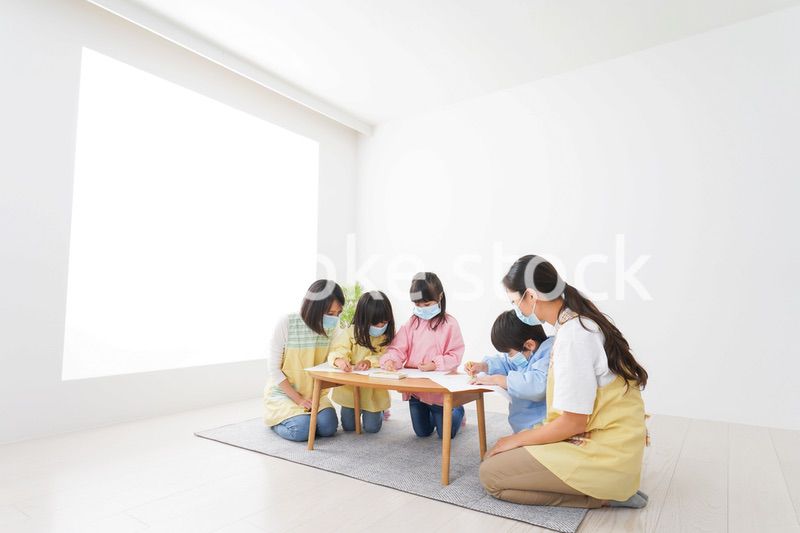 マスクをつけてお絵かきをする幼稚園児と先生