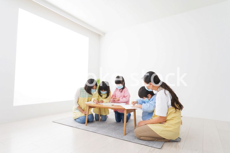 マスクをつけてお絵かきをする幼稚園児と先生