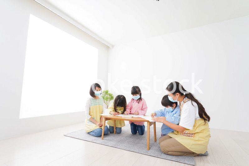 マスクをつけてお絵かきをする幼稚園児と先生