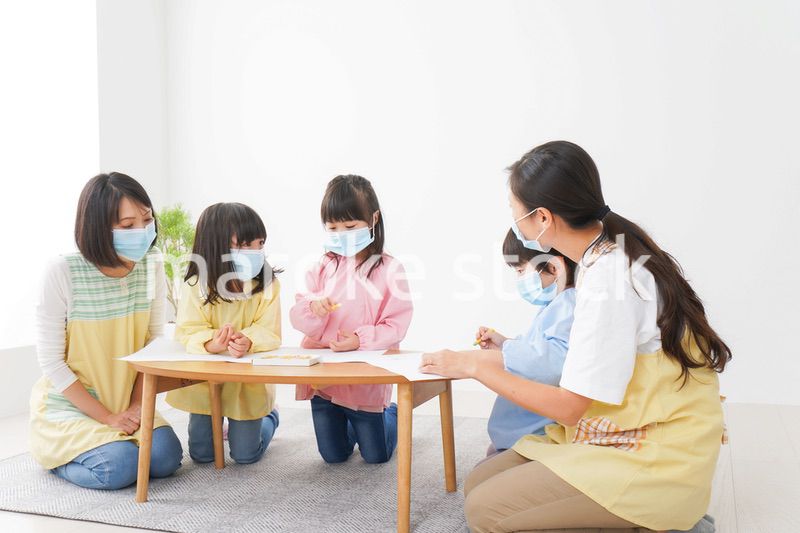 マスクをつけてお絵かきをする幼稚園児と先生