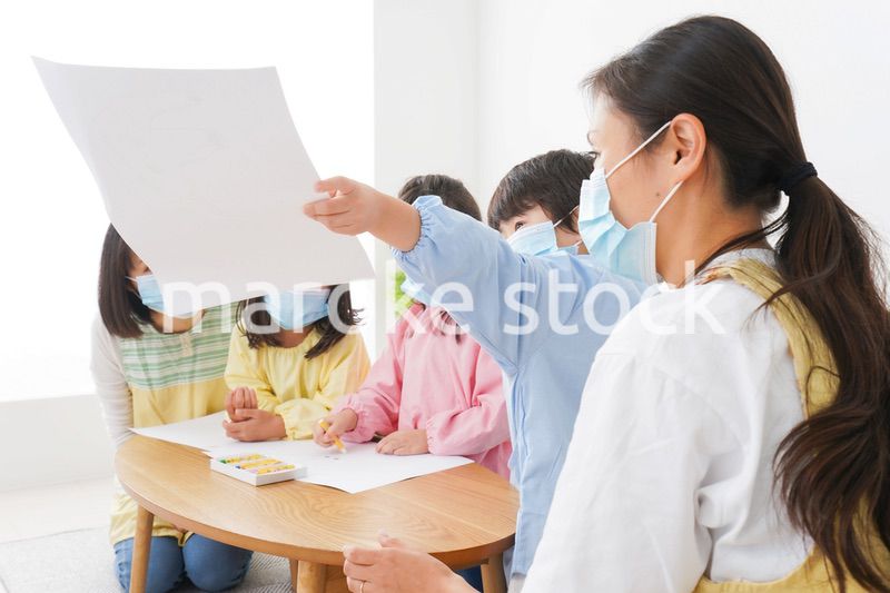マスクをつけてお絵かきをする幼稚園児と先生