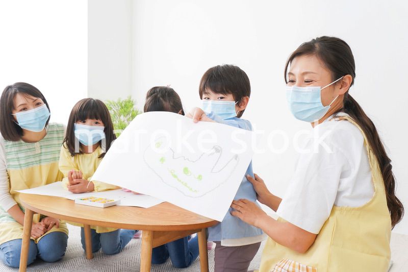 マスクをつけてお絵かきをする幼稚園児と先生