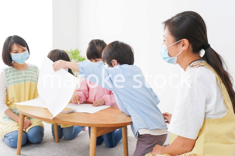 マスクをつけてお絵かきをする幼稚園児と先生
