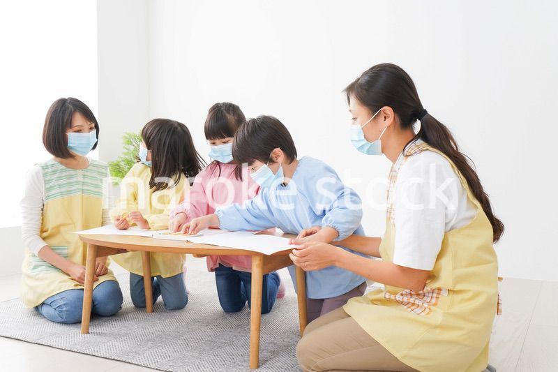 マスクをつけてお絵かきをする幼稚園児と先生