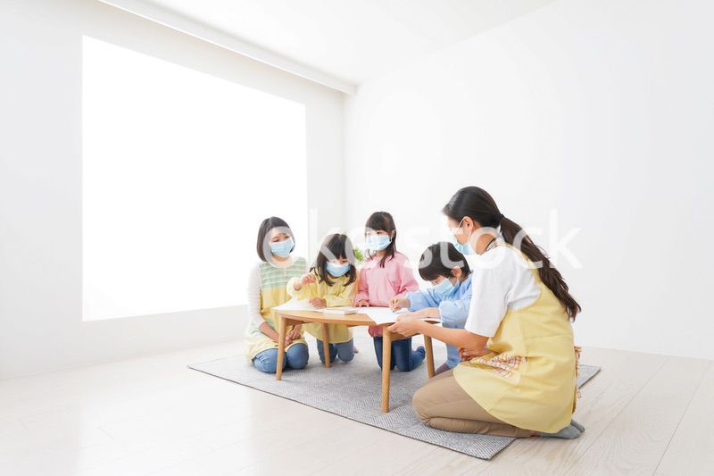 マスクをつけてお絵かきをする幼稚園児と先生