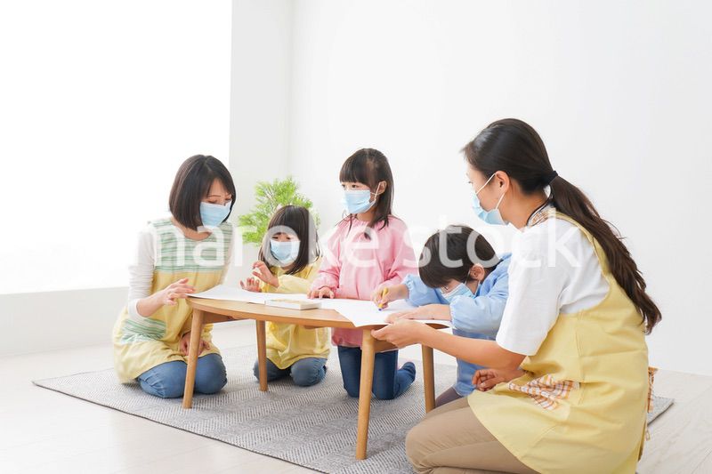 マスクをつけてお絵かきをする幼稚園児と先生