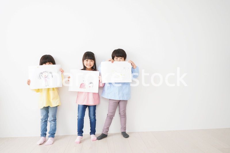 自分で描いた絵を見せる小さな子どもたち