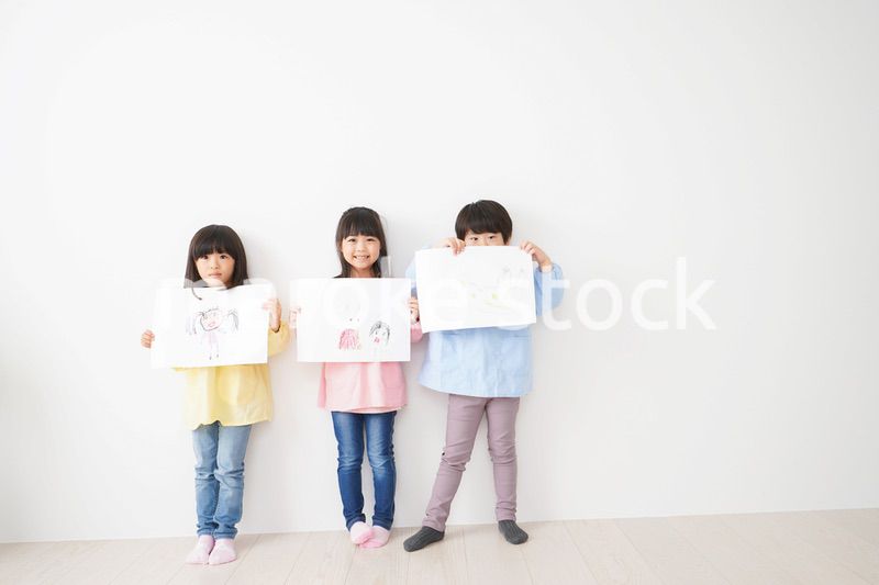 自分で描いた絵を見せる小さな子どもたち