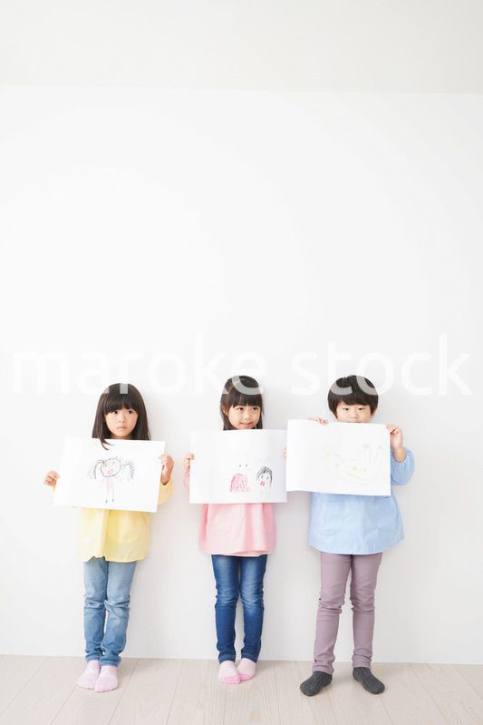 自分で描いた絵を見せる小さな子どもたち