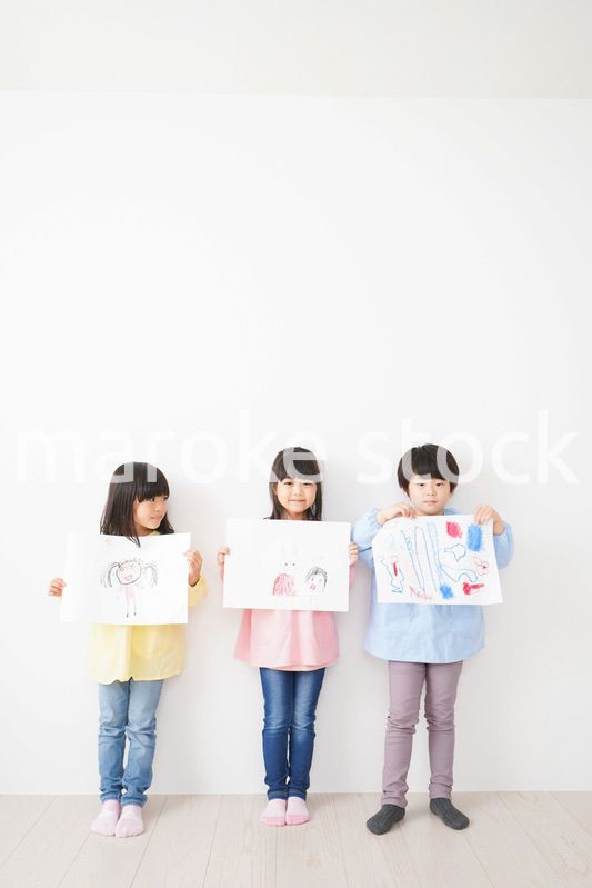 自分で描いた絵を見せる小さな子どもたち