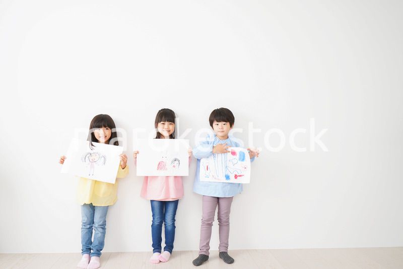 自分で描いた絵を見せる小さな子どもたち
