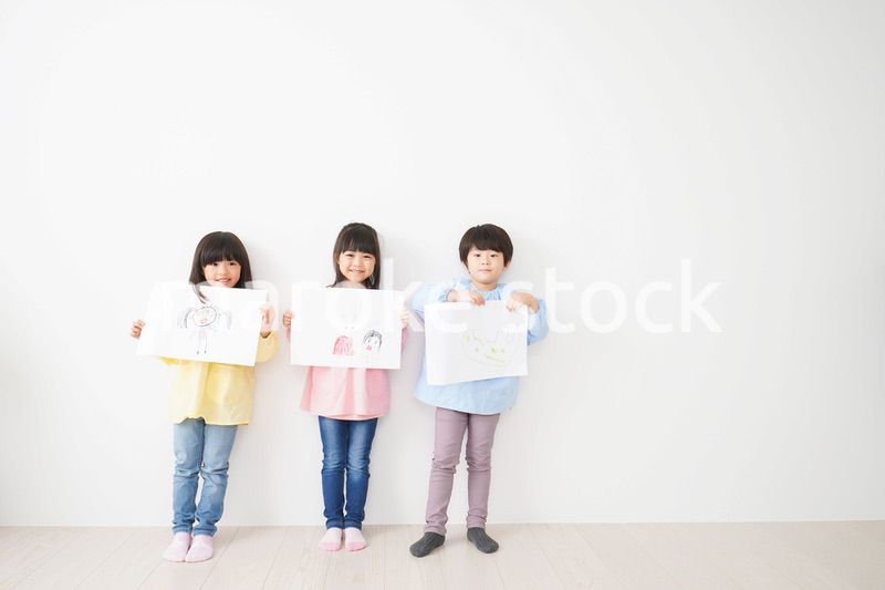 自分で描いた絵を見せる小さな子どもたち