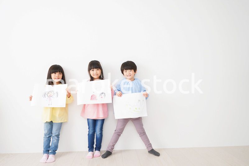 自分で描いた絵を見せる小さな子どもたち