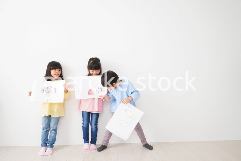 自分で描いた絵を見せる小さな子どもたち