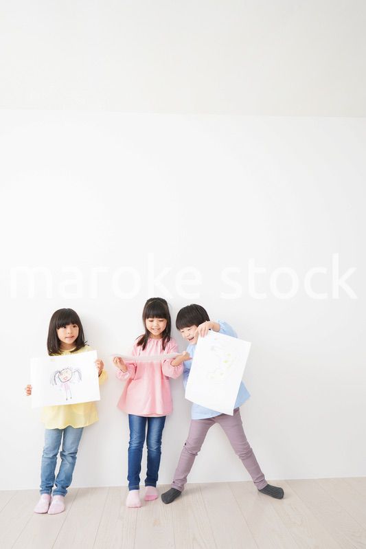 自分で描いた絵を見せる小さな子どもたち