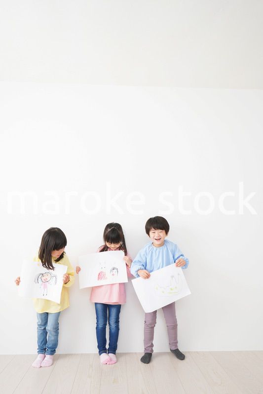 自分で描いた絵を見せる小さな子どもたち