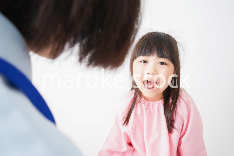 歯医者で治療をしてもらう小さな女の子