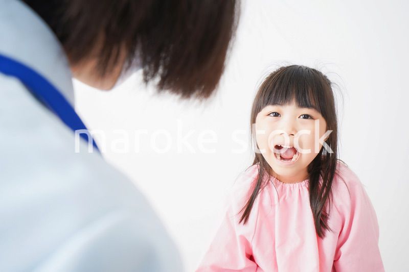 歯医者で治療をしてもらう小さな女の子