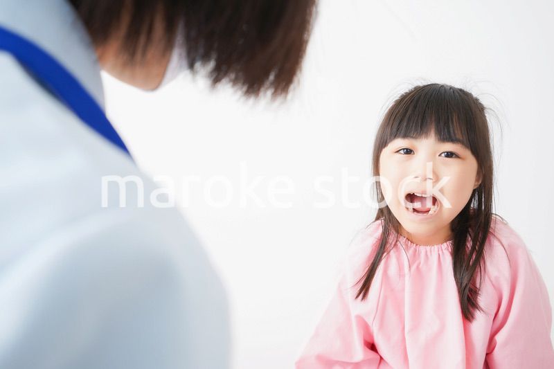 歯医者で治療をしてもらう小さな女の子