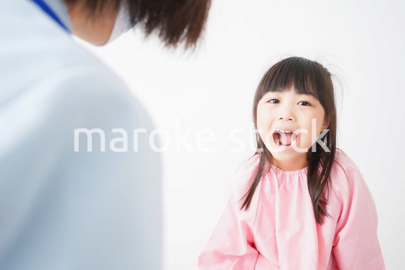 歯医者で治療をしてもらう小さな女の子