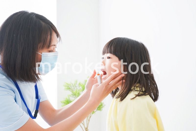 歯医者さんに治療をしてもらう小さな女の子