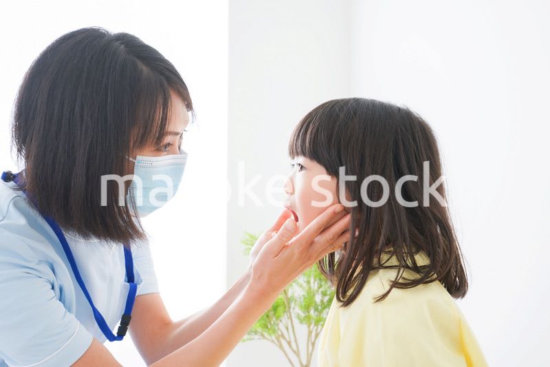 歯医者さんに治療をしてもらう小さな女の子