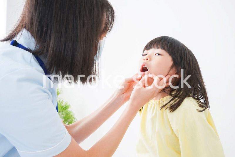 歯医者さんに治療をしてもらう小さな女の子