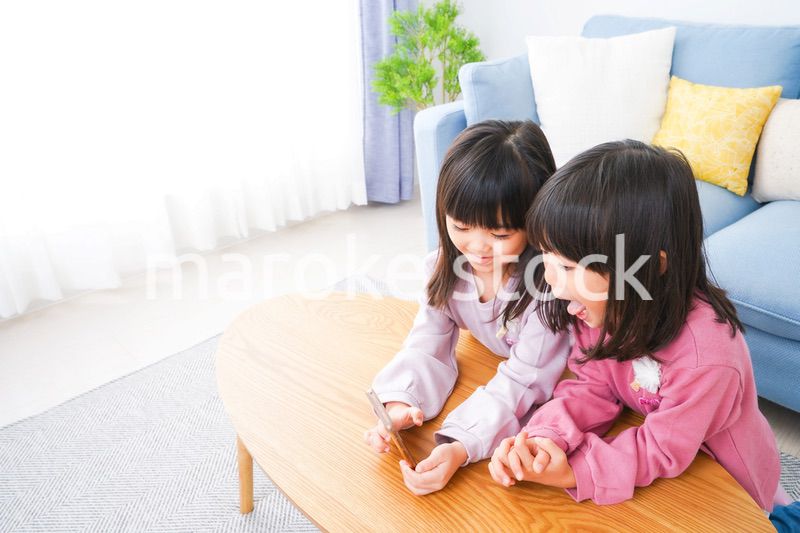 スマホを使う小さな女の子たち