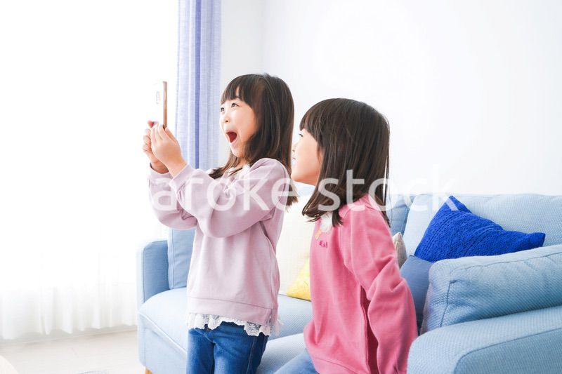 スマホを使う小さな女の子たち