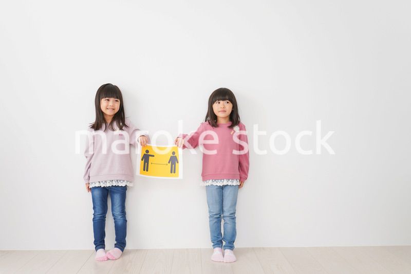 ソーシャルディスタンスの紙を持つ子供
