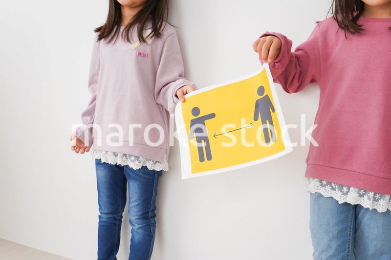 ソーシャルディスタンスの紙を持つ子供