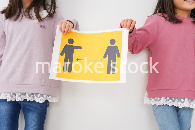 ソーシャルディスタンスの紙を持つ子供