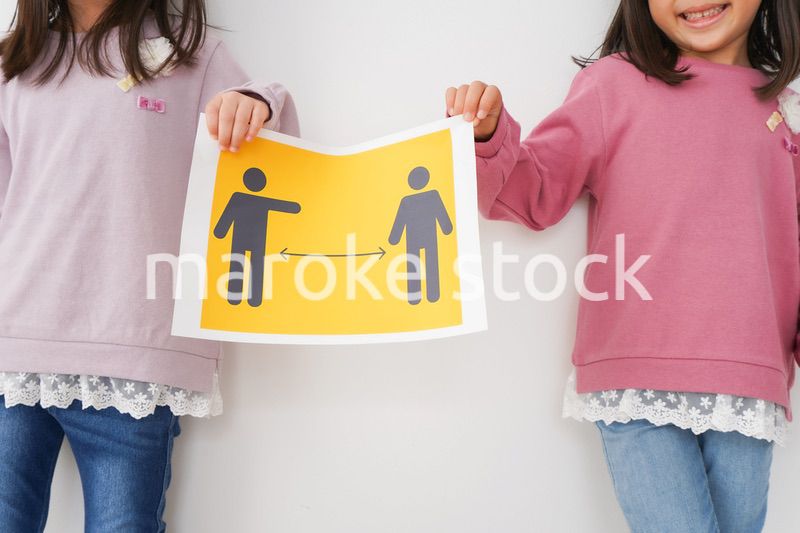 ソーシャルディスタンスの紙を持つ子供