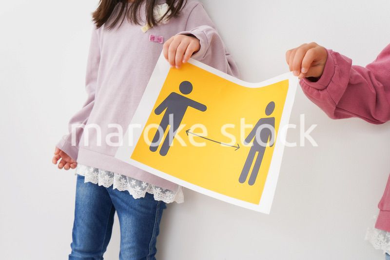 ソーシャルディスタンスの紙を持つ子供