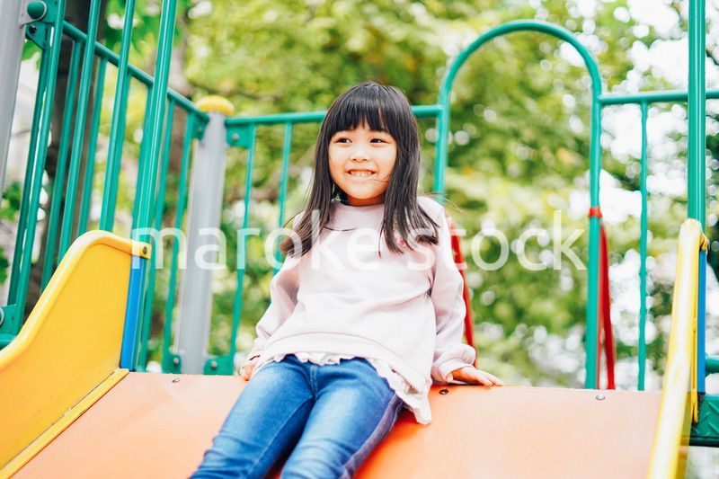 滑り台で遊ぶ小さな女の子