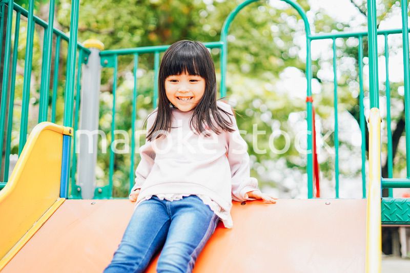 滑り台で遊ぶ小さな女の子
