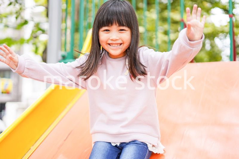 滑り台で遊ぶ小さな女の子