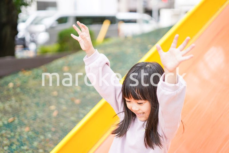 滑り台で遊ぶ小さな女の子
