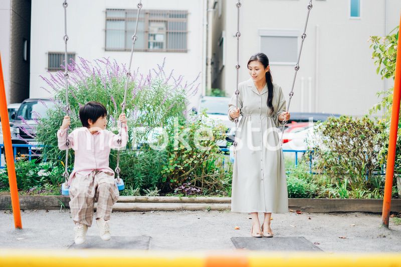 お母さんとブランコに乗る男の子